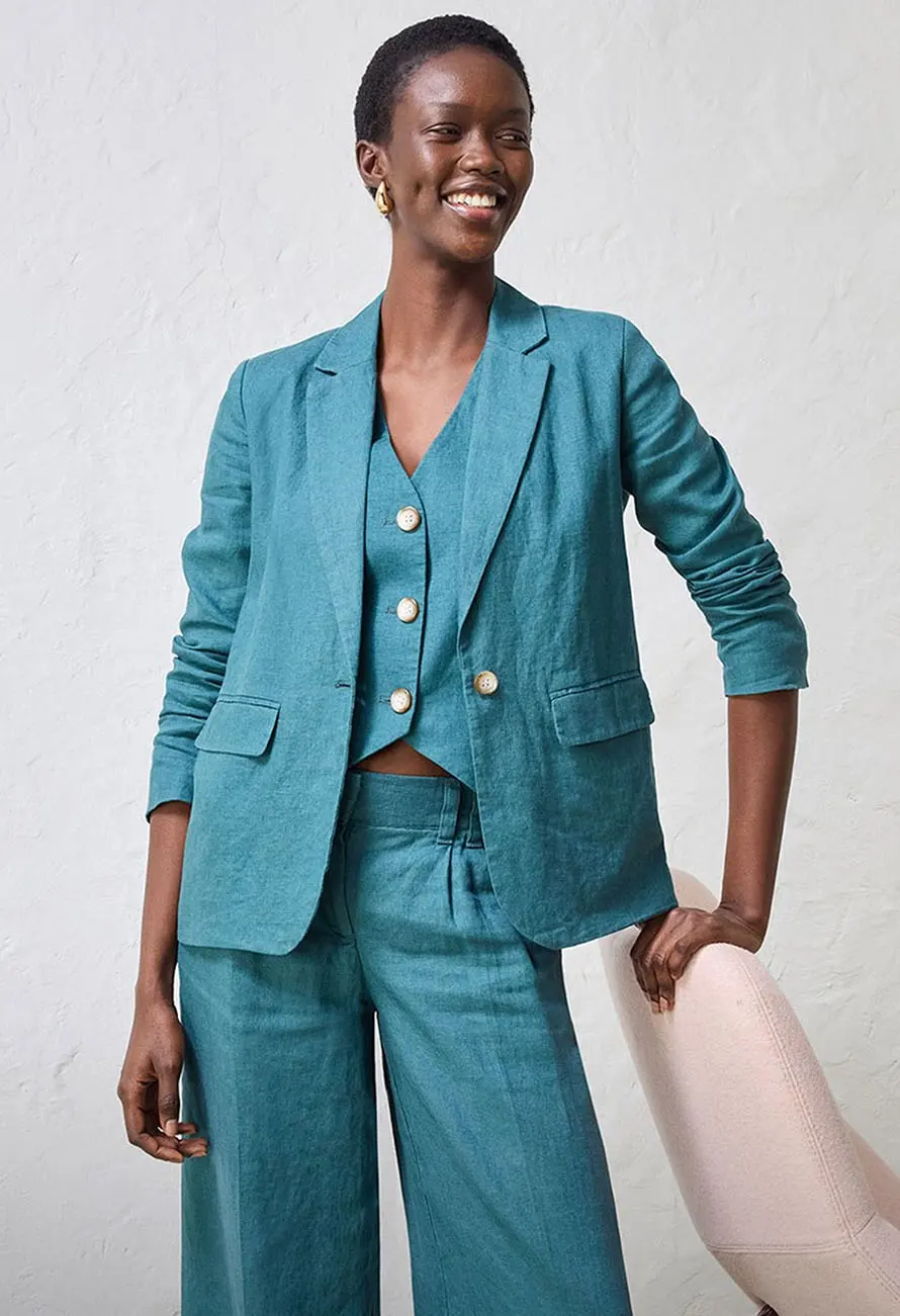 Ensemble tailleur pantalon turquoise avec pantalon large, gilet sans manches et veste.