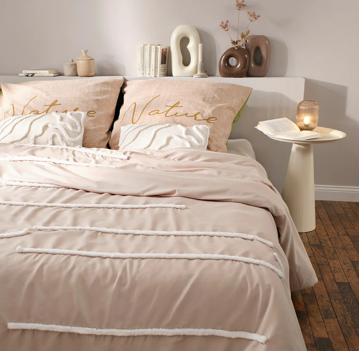 Une parure de lit rose pâle à fines rayures orne la chambre douillette aux tons pastel chaleureux.