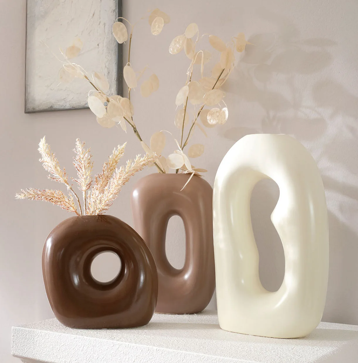 Des vases modernes aux tons terre et blanc.