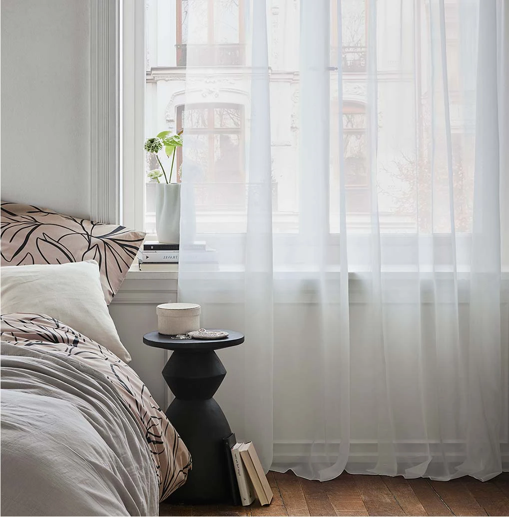 Des voilages blancs transparents décorent la fenêtre.