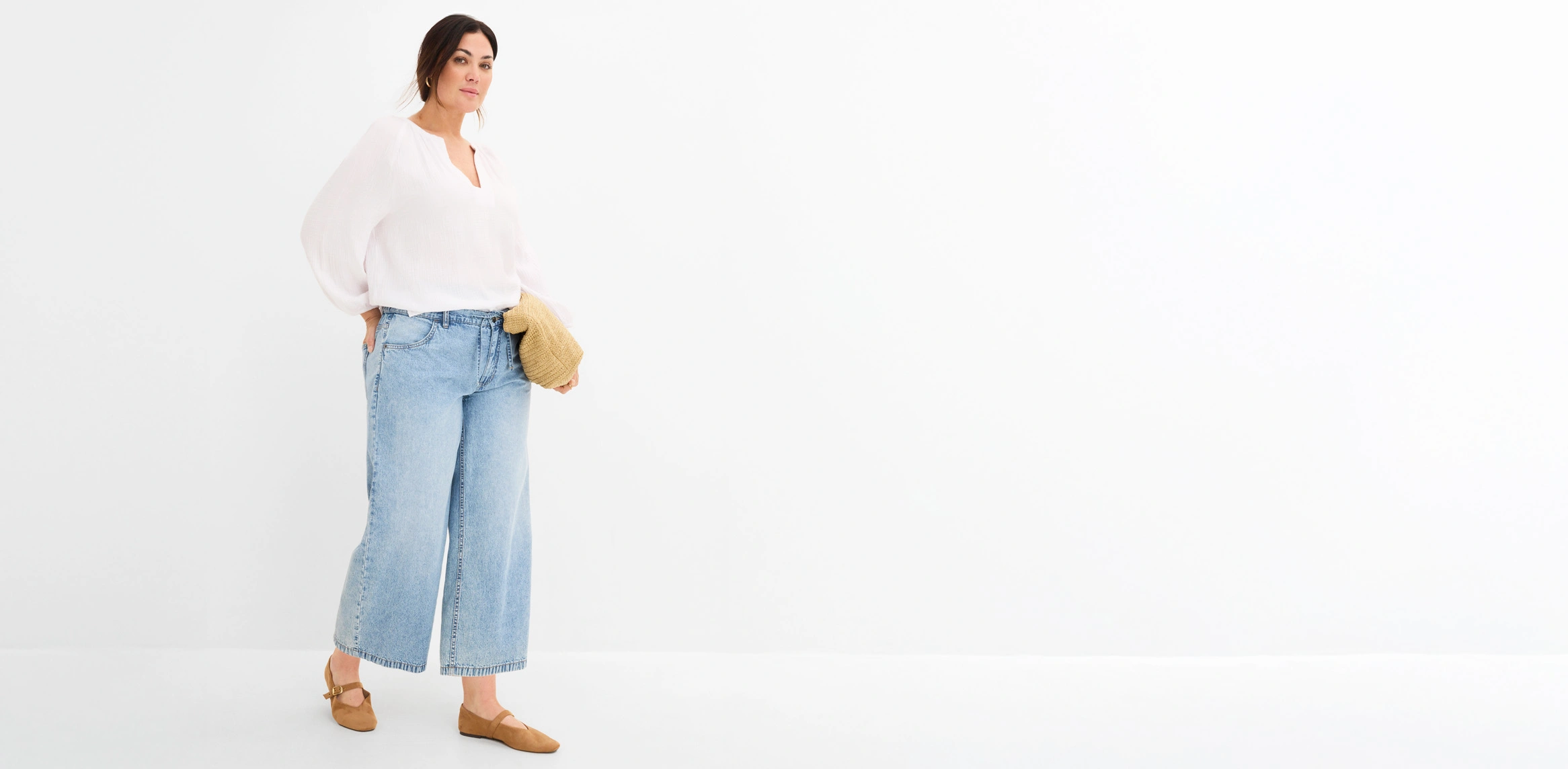 Look décontracté avec une blouse blanche ample, un jean large, des chaussures marron et un petit sac tressé