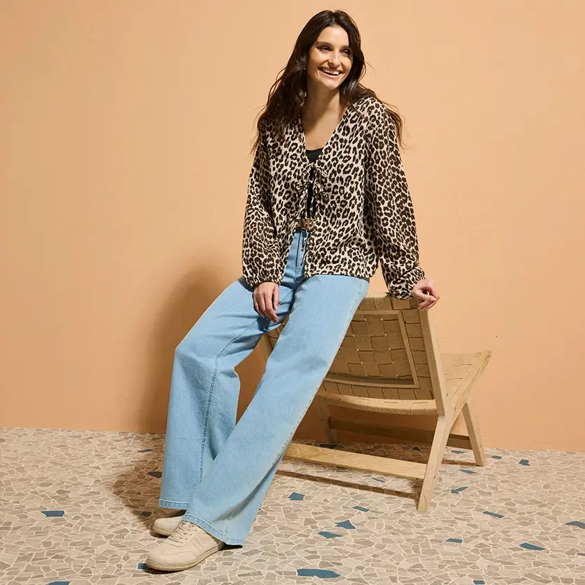 Blouse à imprimé léopard associée à un jean évasé bleu clair.
