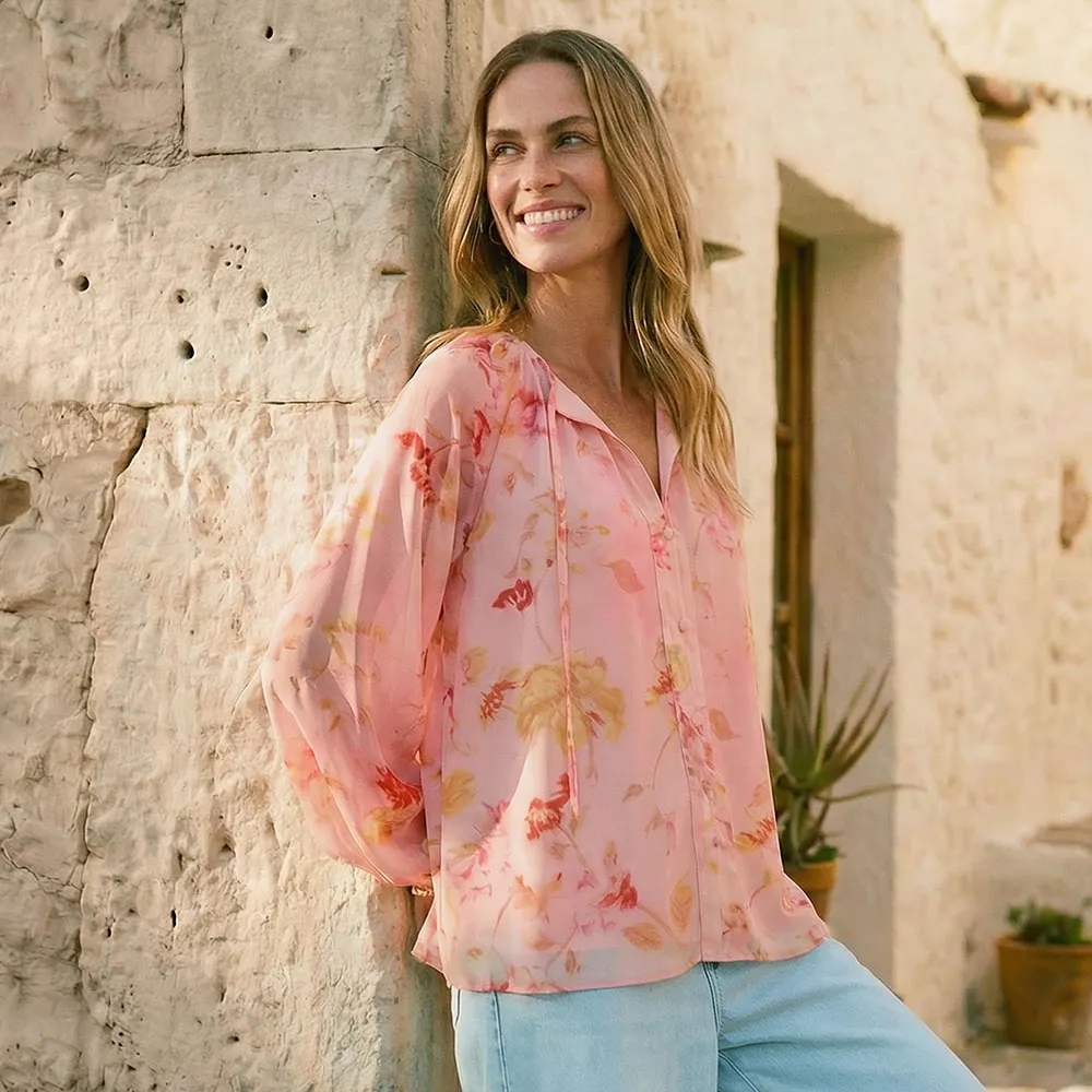 Blouse estivale de couleur rose tendre à motif floral.