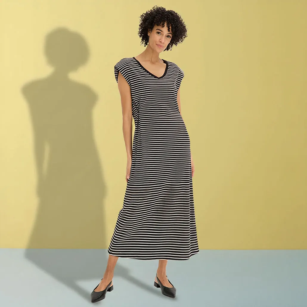 Robe longue rayée noire et blanche élégante avec un décolleté en V et des ballerines noires.