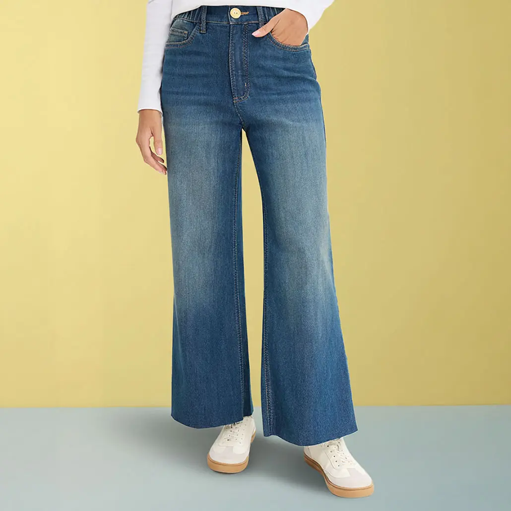 Jean large, haut blanc et sneakers de couleur claire.