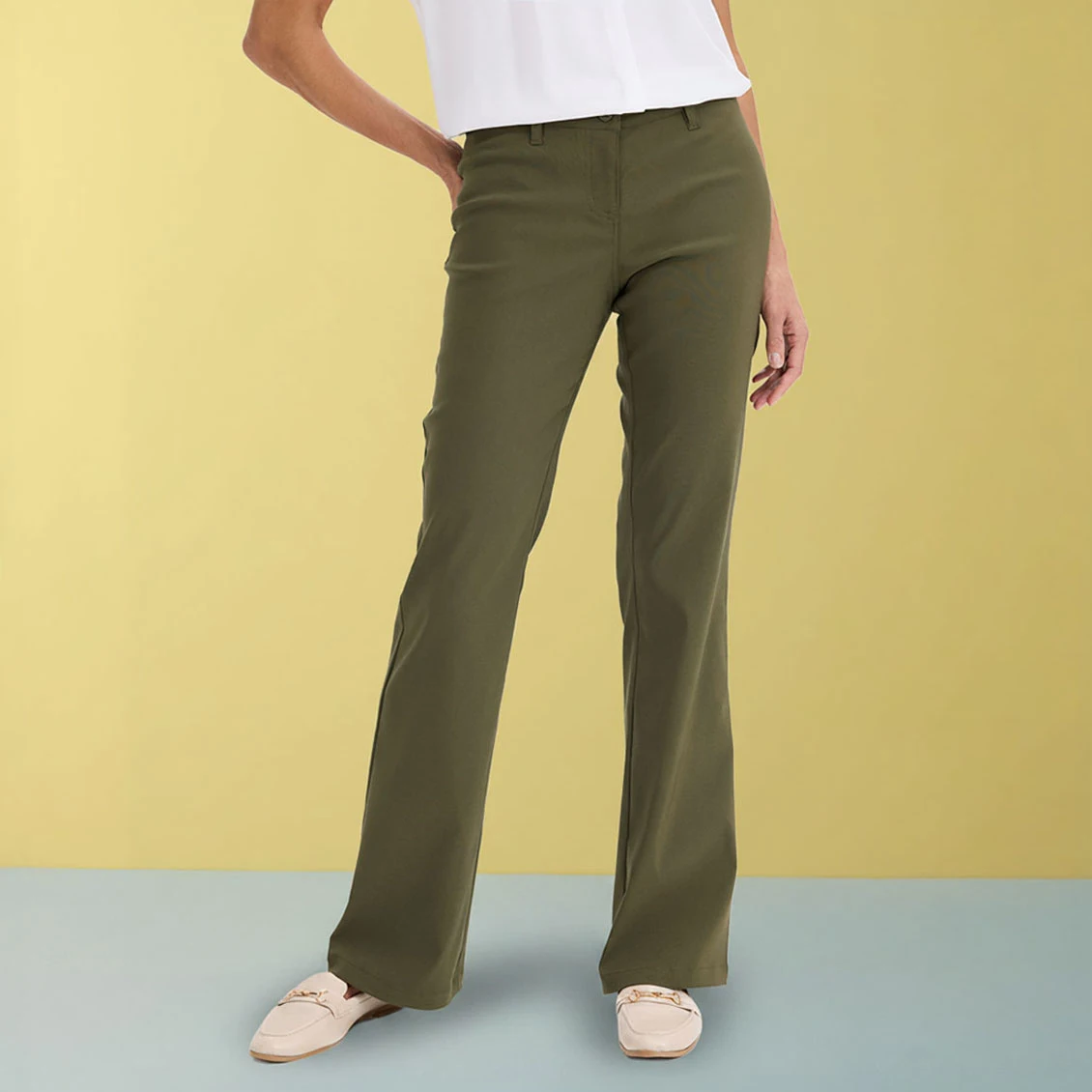 Pantalon vert olive élégant associé à un haut blanc et des chaussures beige.