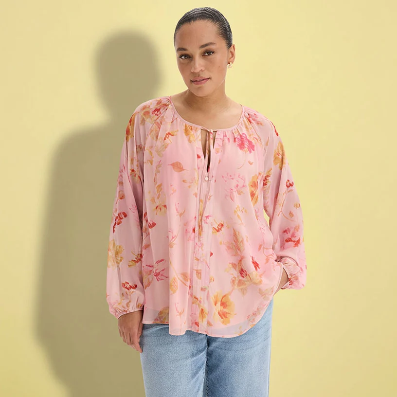 Une blouse rose à motif floral et jean ample.