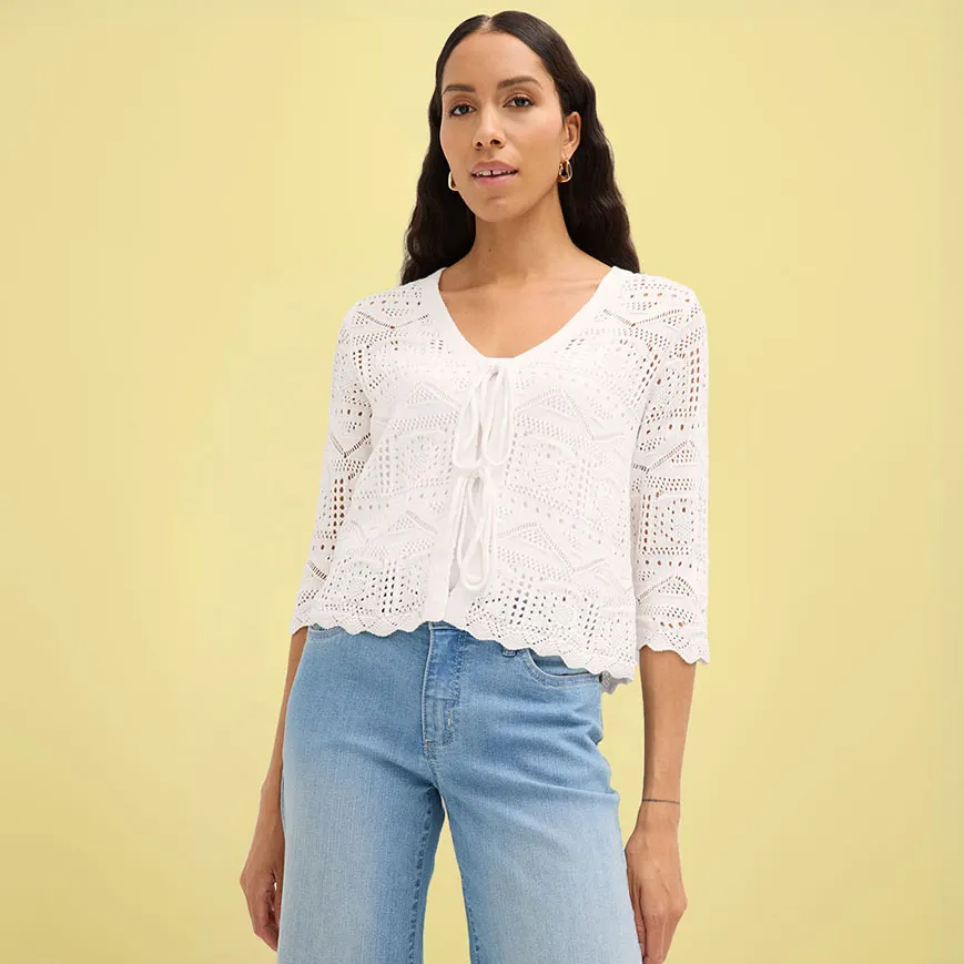 Gilet blanc en maille crochetée avec manches 1/2 associé à un jean bleu.