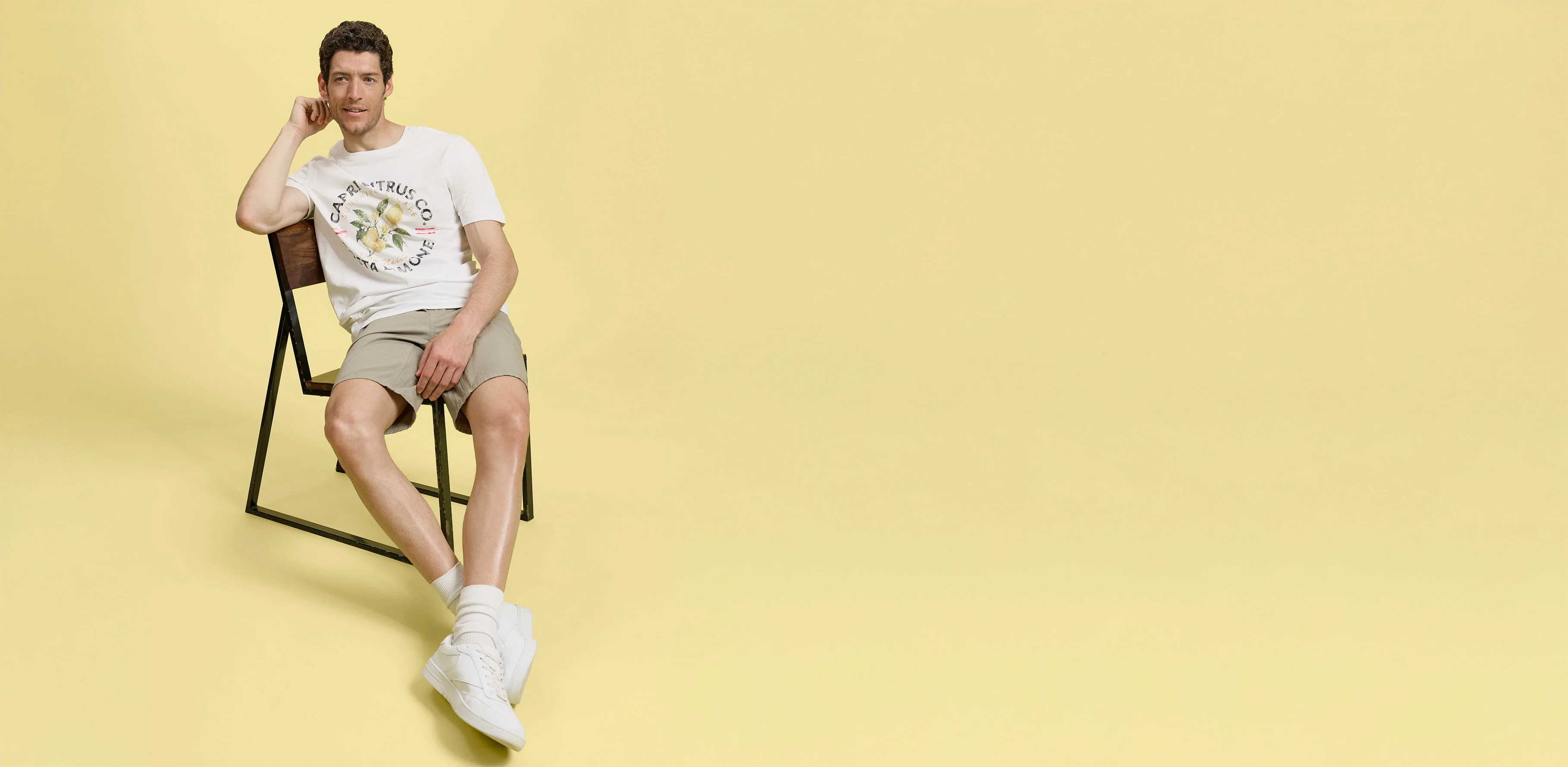 Tenue estivale avec short beige, T-shirt blanc et tennis confortables. 