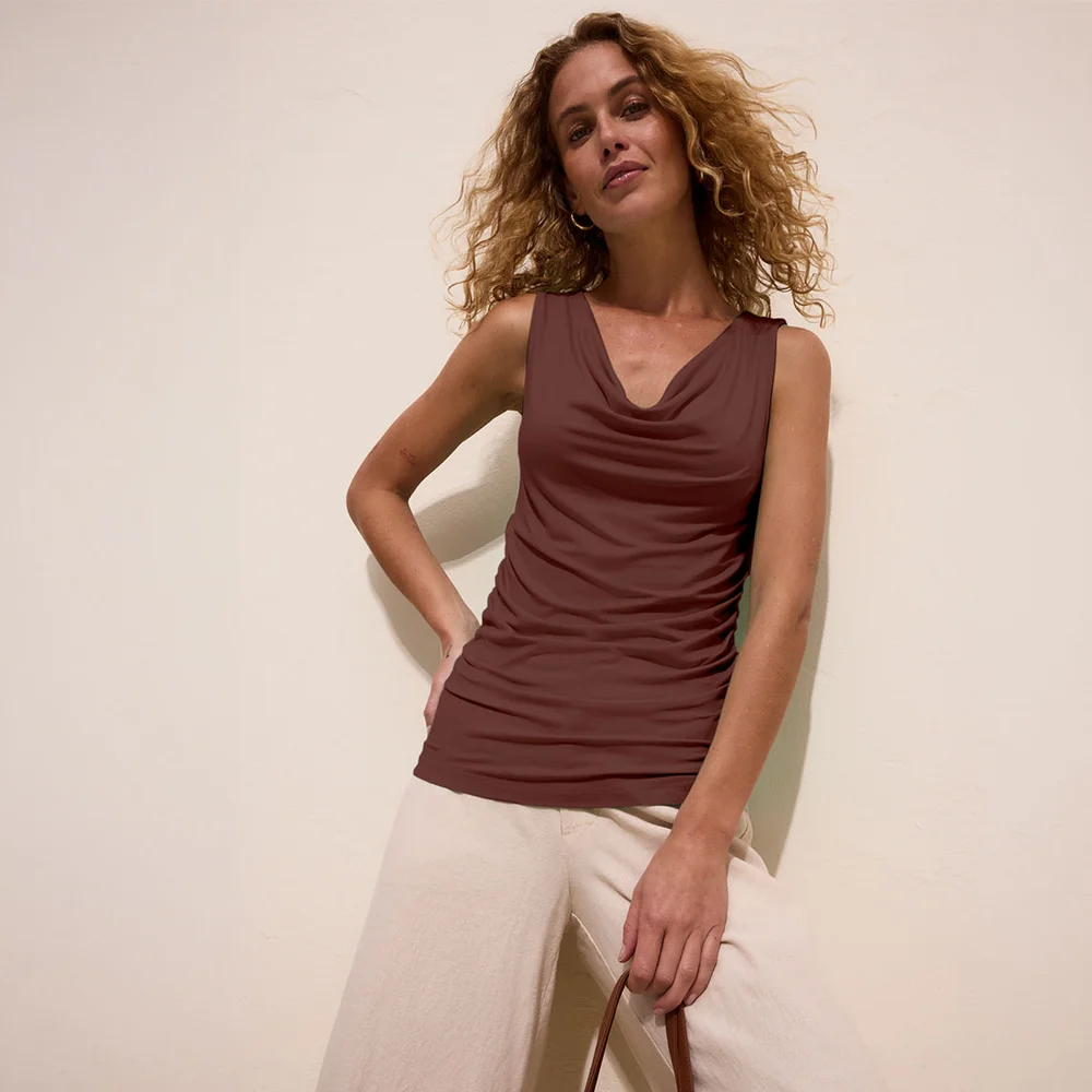 Top marron à décolleté drapé, associé à un pantalon clair à coupe large.