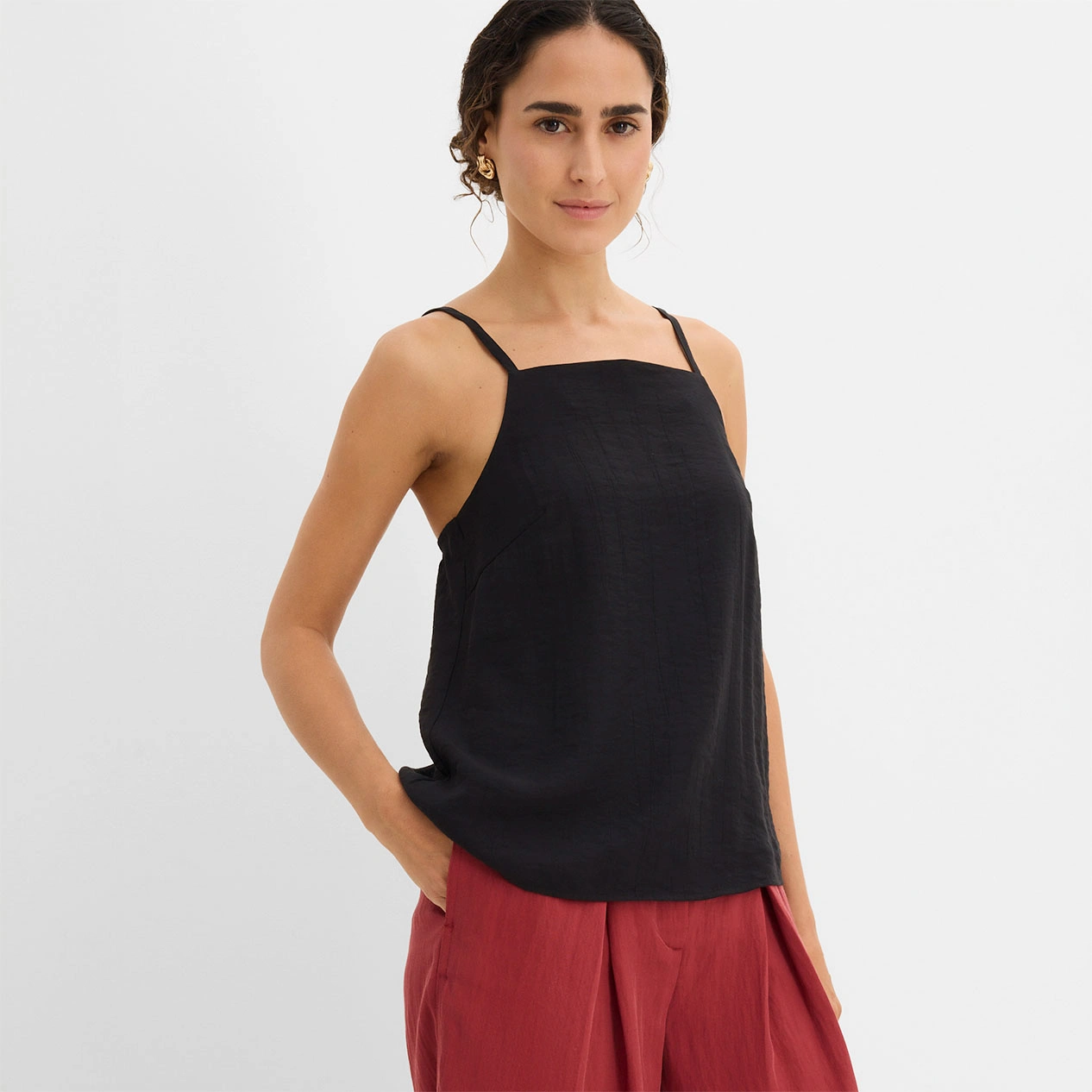 Top noir associé à un pantalon large rouge pour un look décontracté tendance.