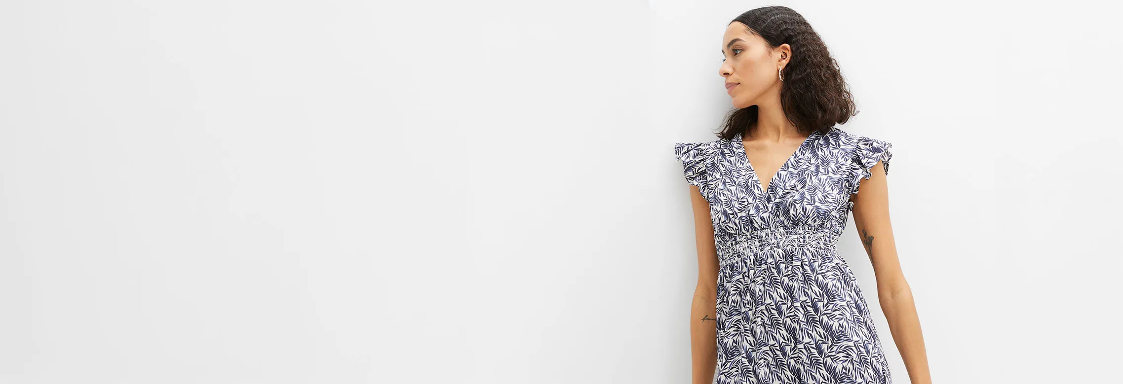 Robe estivale élégante à motif végétal bleu, décolleté en V et fronces à la taille.