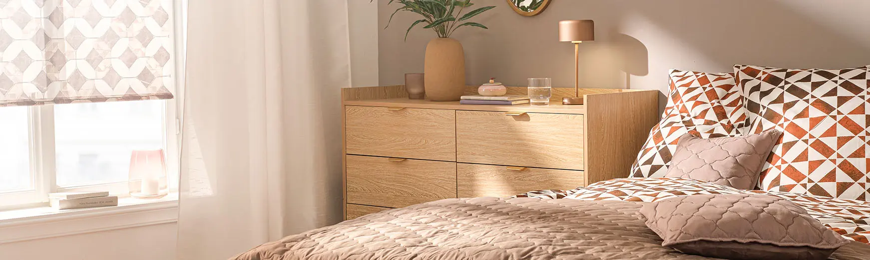 Parure de lit imprimée dans des tons orange et marron, rehaussée d'une couverture matelassée et de coussins déco.