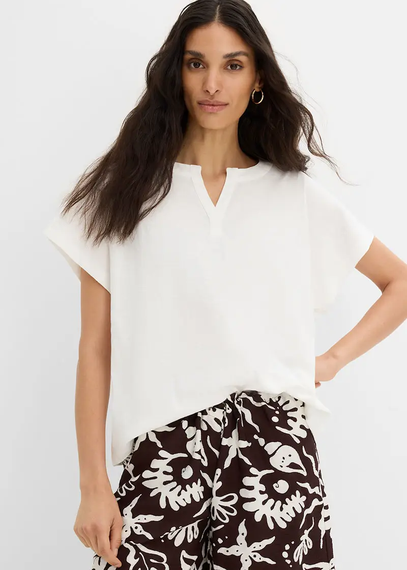 Blouse blanche aérienne à décolleté en V et pantalon imprimé blanc et marron à motifs.