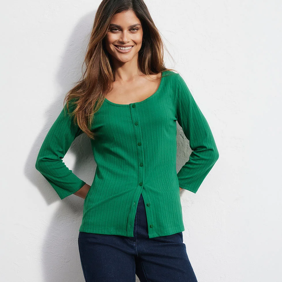Haut vert côtelé avec patte de boutonnage et jean noir pour un look décontracté.