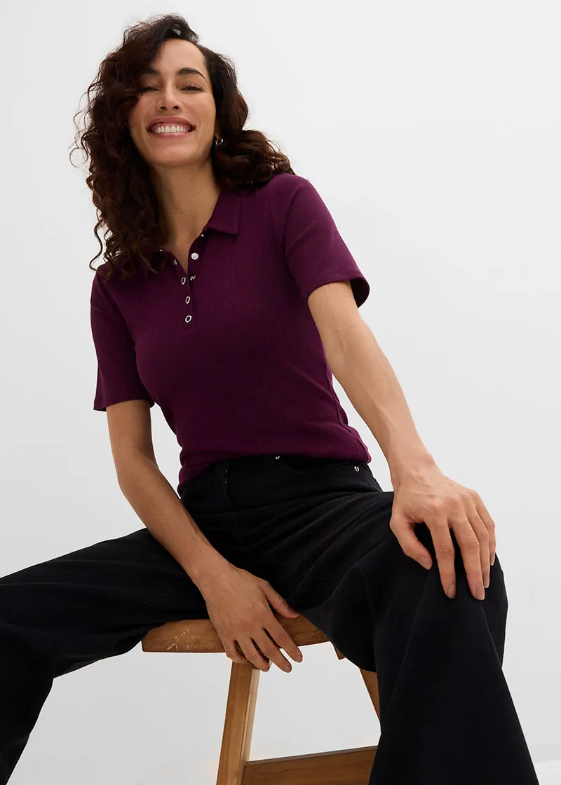 Polo rouge bordeaux à boutons et pantalon large noir.