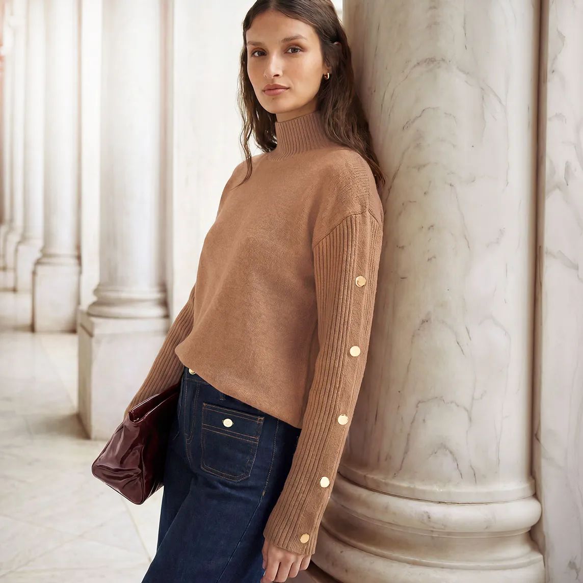 Pull à col roulé mode avec boutons, jean large et sac élégant.