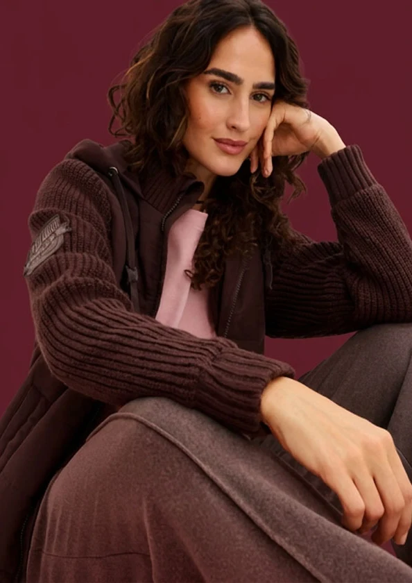 Gilet chaud en maille avec manches côtelées, top rose et pantalon assorti dans des tons bruns.