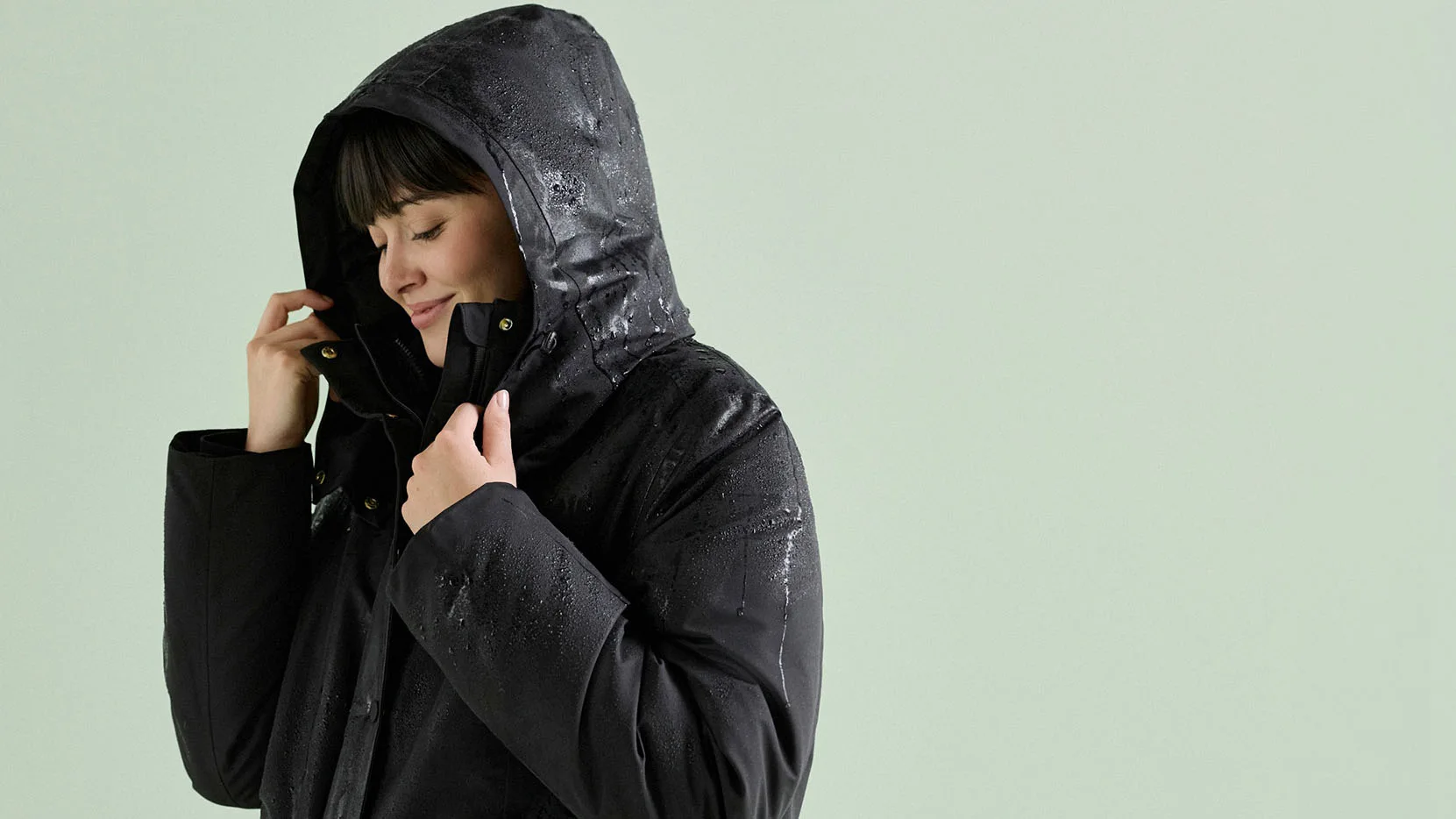 Look hivernal : parka noire à capuche.