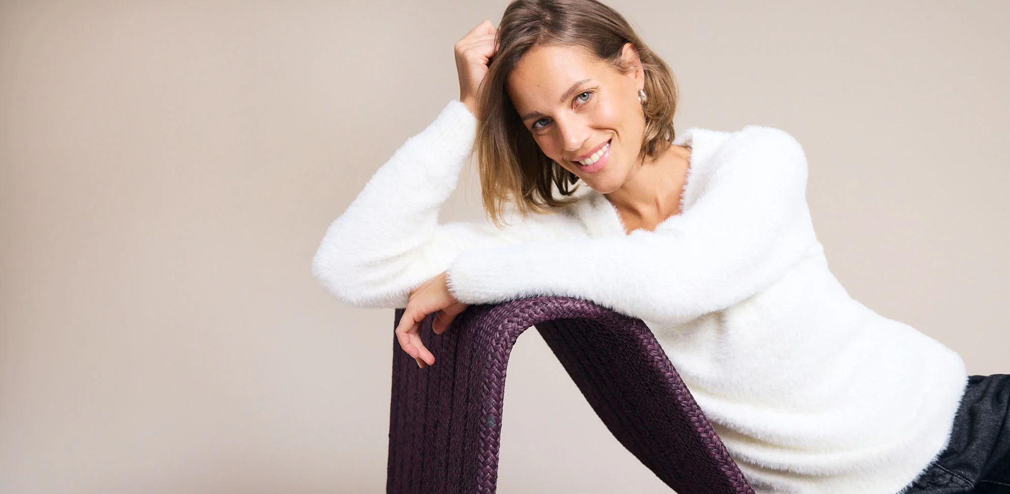 Pull blanc duveteux et pantalon foncé pour un style confortable et décontracté.