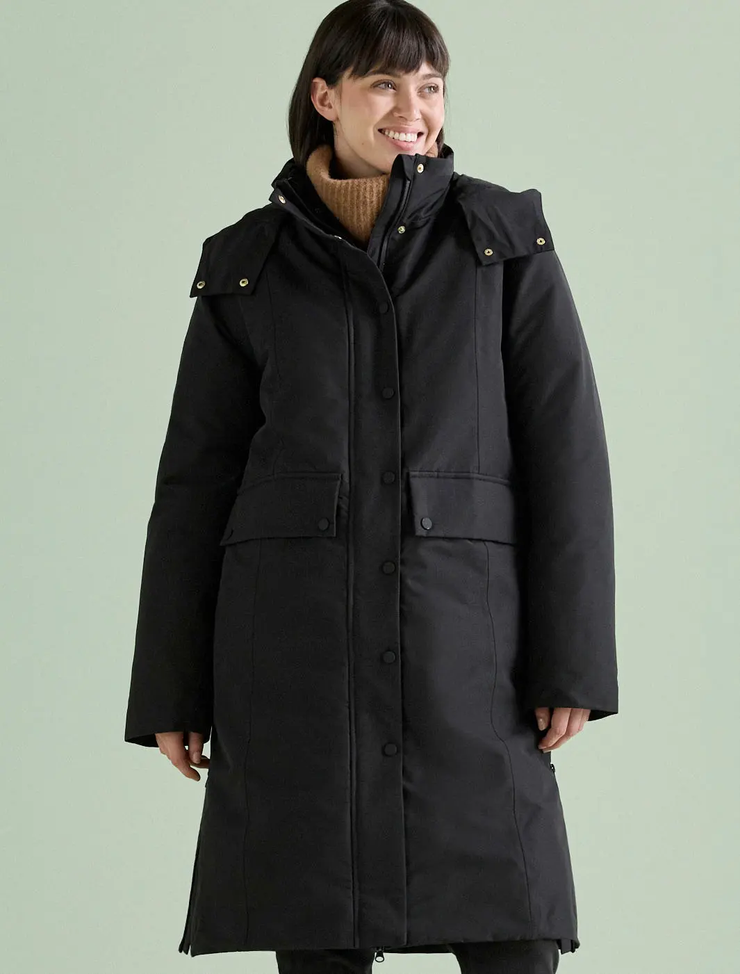 Une femme vêtue d'un long manteau d'hiver noir.